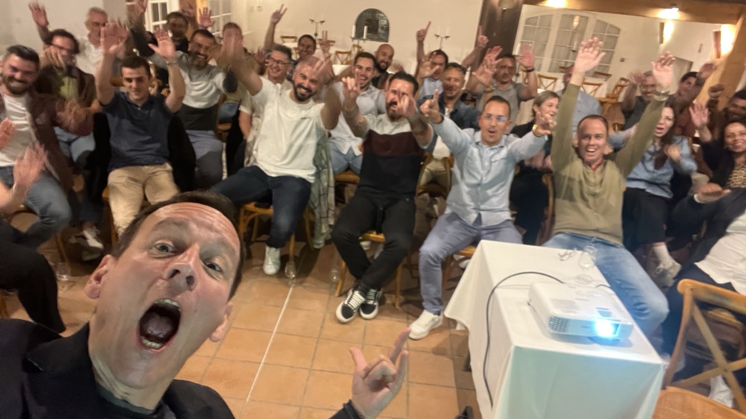Participants debout, bras levés, à la fin d'un séminaire animé par Iker Aguirre