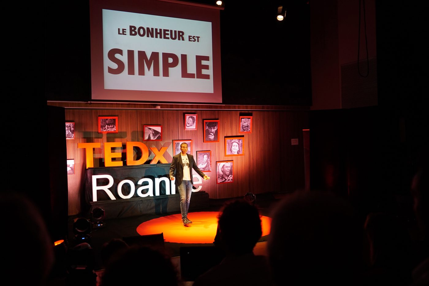 Iker Aguirre en el escenario del TEDx Roanne — «La felicidad es sencilla» en pantalla